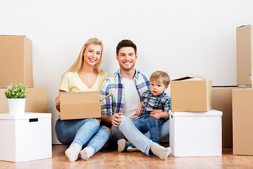 mortgage, people, family and real estate concept - happy mother, father and little son with cardboard boxes moving to new home