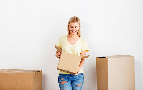 moving, people and real estate concept - happy man holding cardboard box at new home