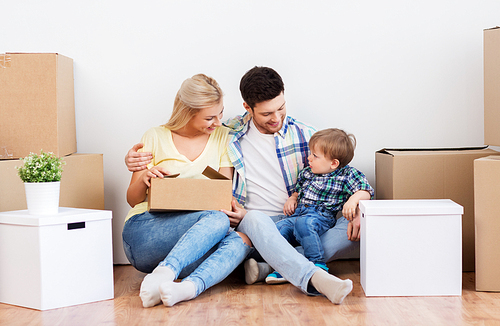 mortgage, people, family and real estate concept - happy mother, father and little son with cardboard boxes moving to new home