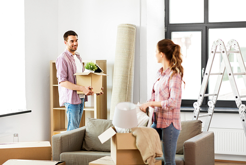 home, people, repair and real estate concept - smiling couple with big cardboard boxes and stuff moving to new place