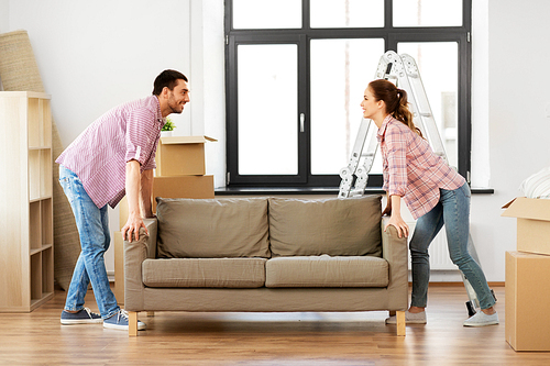 accommodation, repair and real estate concept - happy couple moving sofa at new home