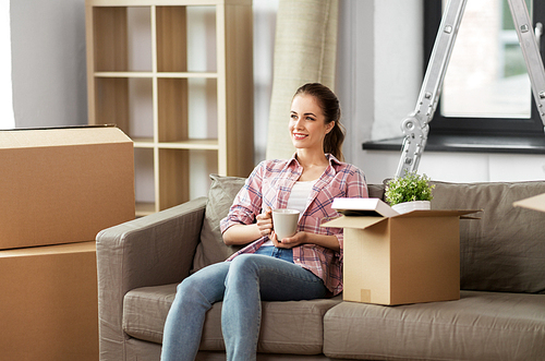 people, repair and real estate concept - smiling woman with stuff moving to new home and drinking coffee