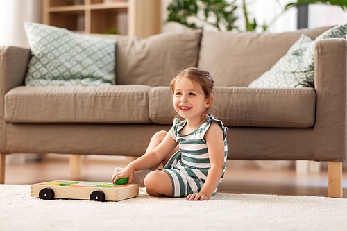 childhood and people concept - happy three years old baby girl playing with toy blocks at home