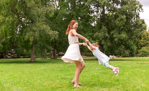 family, childhood and parenthood concept - happy mother with little baby girl playing and having fun at summer park