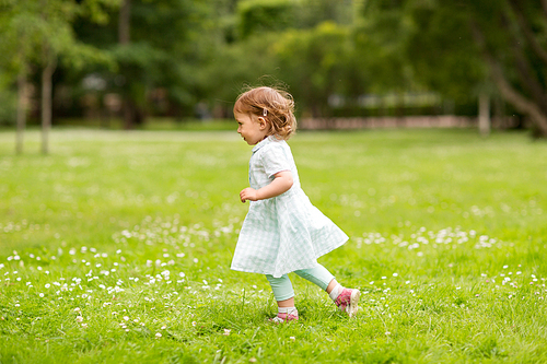 childhood, leisure and people concept - happy little baby girl running at park in summer