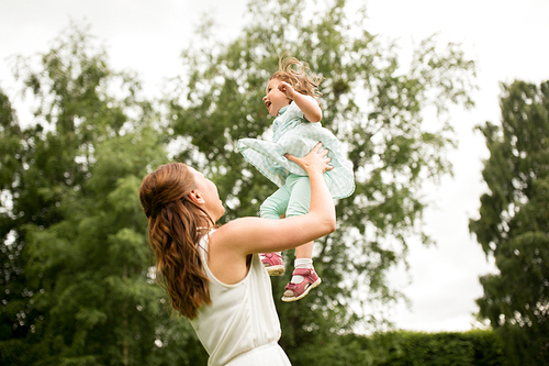 family, childhood and motherhood concept - happy mother with baby daughter at summer park