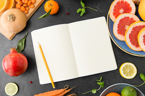 food, healthy eating and diet concept - close up of notebook, fruits and vegetables on slate table top