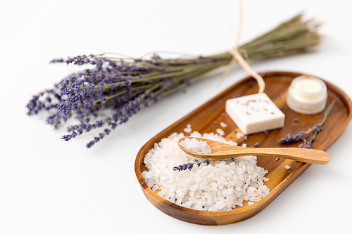 beauty and wellness concept - 씨솔트 with spoon, lavender, soap bar and moisturizer on wooden tray
