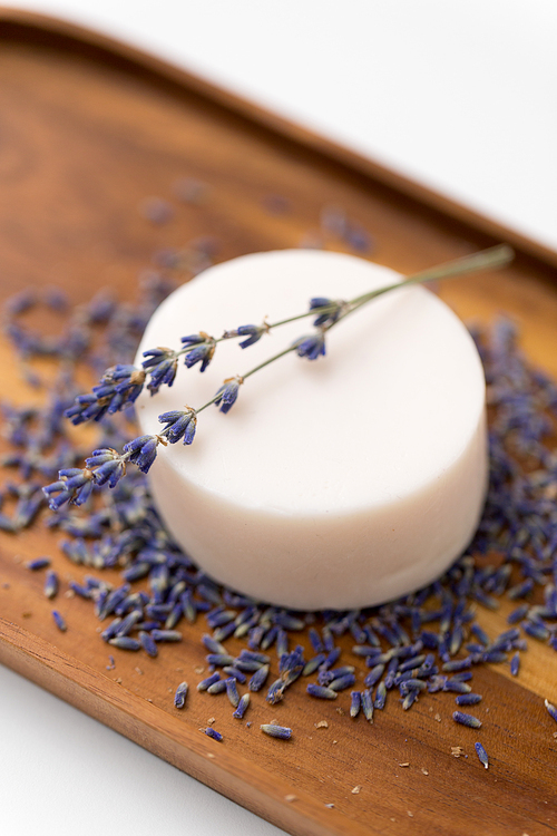beauty, spa and wellness concept - close up of crafted lavender soap on wooden tray