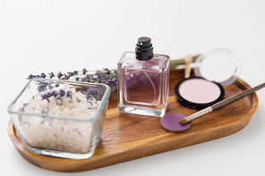 beauty, make up and wellness concept - sea salt, perfume, lavender and mineral cosmetics on wooden tray