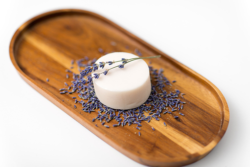 beauty, spa and wellness concept - close up of crafted lavender soap on wooden tray