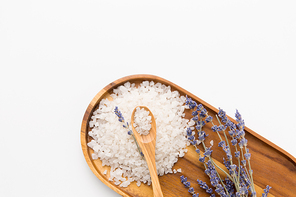 beauty and wellness concept - sea salt heap and lavender on wooden tray