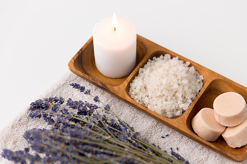 beauty and wellness concept - 씨솔트, soap and candle on wooden tray and bunch of lavender on bath towel