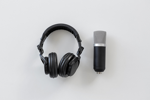 technology, sound recording and audio equipment concept - headphones and microphone on white background