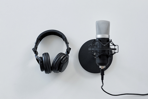 technology, sound recording and audio equipment concept - headphones and microphone on white background