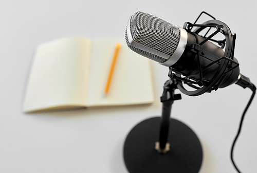 technology and audio equipment concept - close up of microphone on white background