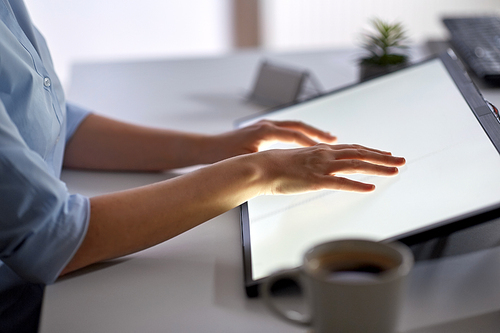 technology and people concept - hands on led light tablet or touch screen at night office