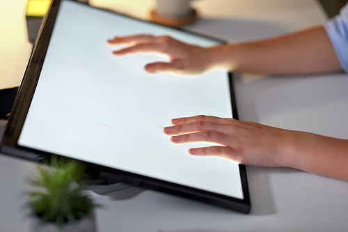 technology and people concept - hands on led light tablet or touch screen at night office