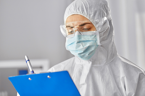 health safety, medicine and pandemic concept - close up of female doctor or scientist in protective wear, medical mask and goggles for protection from virus disease with clipboard