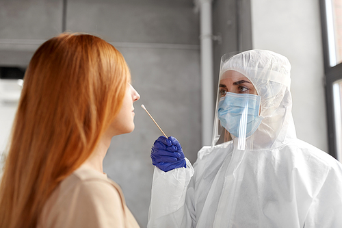 medicine, health and virus concept - doctor or healthcare worker in protective wear, medical mask and face shield making coronavirus test and taking sample from patient