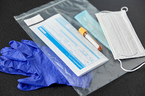 medicine, healthcare and pandemic concept - test tube, cotton swab with medical report in plastic zipper bag and protective gloves with medical mask on table
