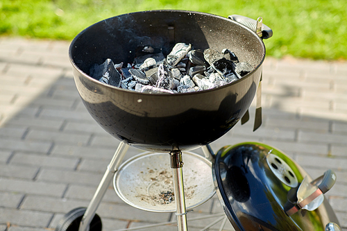 cooking, heat and fire concept - charcoal smoldering in brazier outdoors