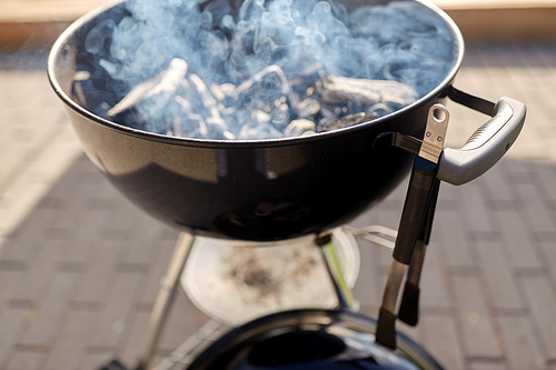 cooking, bbq and grilling concept - close up of charcoal smoldering in brazier outdoors