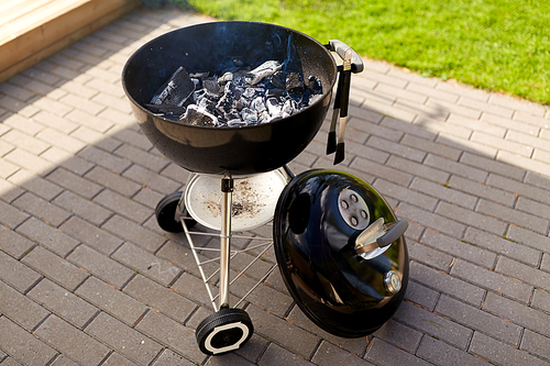 cooking, bbq and grilling concept - charcoal smoldering in brazier outdoors