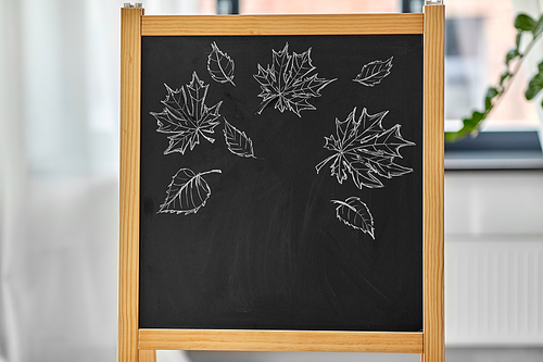 education and learning concept - autumn leaves drawn with chalk on chalkboard