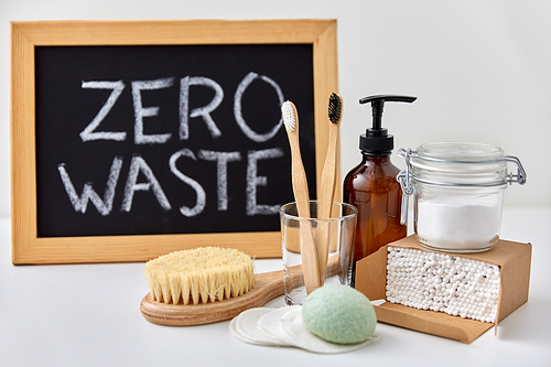 beauty, sustainability and eco living concept - natural cosmetics, bodycare, hygienic eco products and chalkboard with zero waste words or lettering on white background