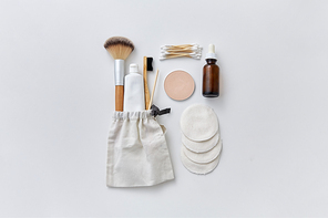 natural cosmetics and eco living concept - wooden make up brush, cotton pads and swabs, toothbrush with toothpaste and essential oil or serum on white background