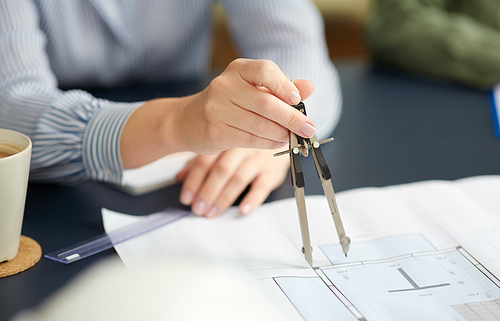 construction business, architecture and building concept - close up of architect with blueprint and drafting compass working at office