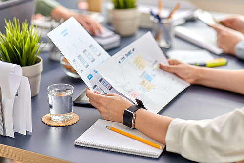 business, people and technology concept - close up of ui designer with mockups working on mobile app design at office