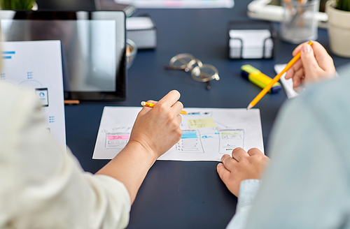 business, people and team work concept - close up of team of startuppers with gadgets and papers working at office table