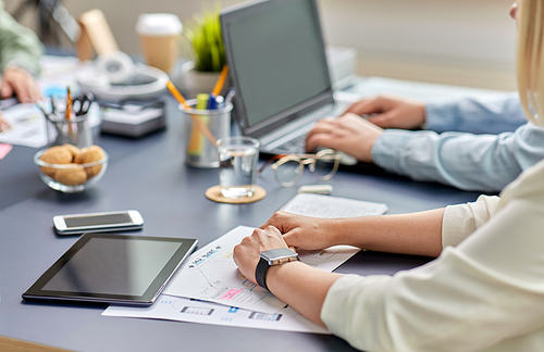 business, people and technology concept - close up of ui designer with mockups working on mobile app design at office