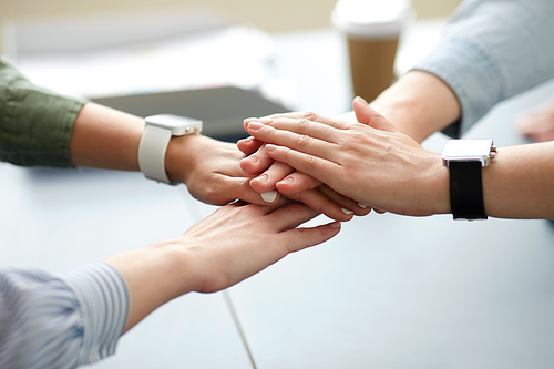 cooperation, corporate and team work concept - close up of business team stacking hands at office