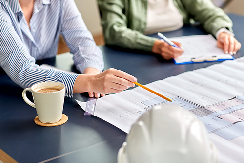 construction business, architecture and team work concept - close up of architects with blueprint, gadgets and papers working at office table