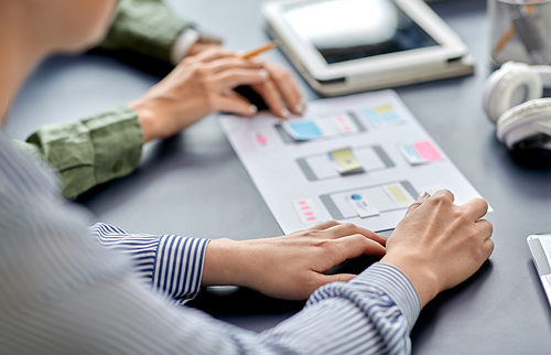 business, people and team work concept - close up of team of startuppers with gadgets and papers working at office table