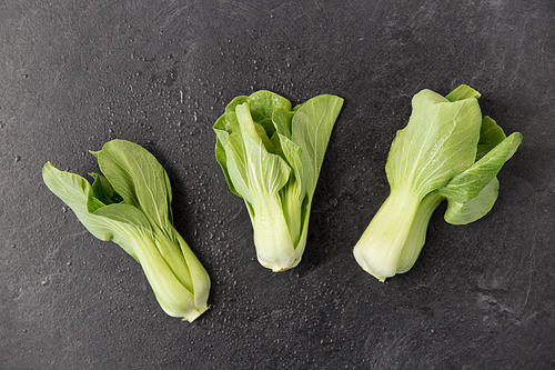 vegetable, food and culinary concept - close up of bok choy chinese cabbage on slate stone background