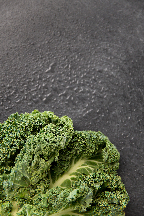 vegetable, food and culinary concept - close up of kale cabbage on slate stone background