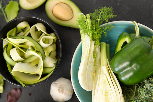 vegetable, food and culinary concept - close up of fennel, green pepper or paprika, peeled zucchini, avocado and garlic