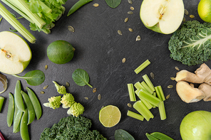 food, culinary and healthy eating concept - close up of different green vegetables and fruits on slate stone background