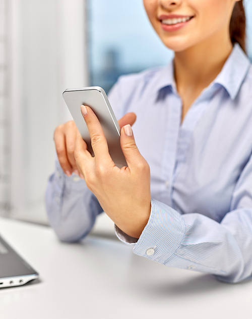 business, technology and people concept - close up of happy smiling businesswoman with smartphone at office