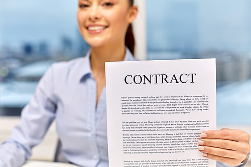 business agreement, documents and people concept - happy businesswoman holding contract at office