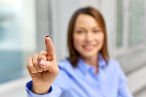 business and people concept - close up of smiling businesswoman touching something with finger