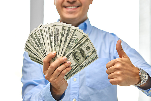 business, people and finances concept - close up of smiling businessman with american dollar money showing thumbs up