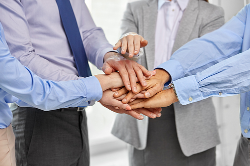people, gesture and teamwork concept - close up of business team stacking hands