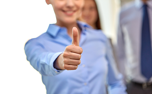 business people, gesture and success concept - close up of happy smiling businesswoman showing thumbs up