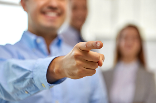 business, gesture and people concept - close up of smiling businessman pointing finger
