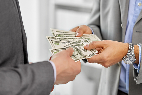 business, people and finances concept - close up of businessmen's hands holding american dollar money